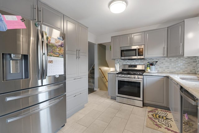 6130 Belmont Rd, Downers Grove, IL 60516 - kitchen with stainless steel appliances, gray cabinetry, decorative backsplash, and light stone countertops
