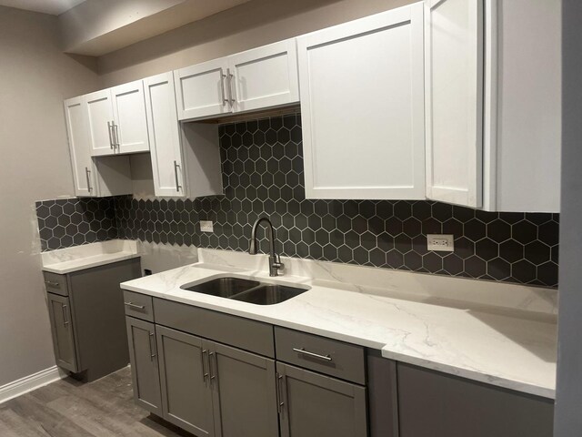 7232 S Rhodes Ave, Chicago, IL 60619 - kitchen featuring a sink, light stone counters, gray cabinetry, and tasteful backsplash