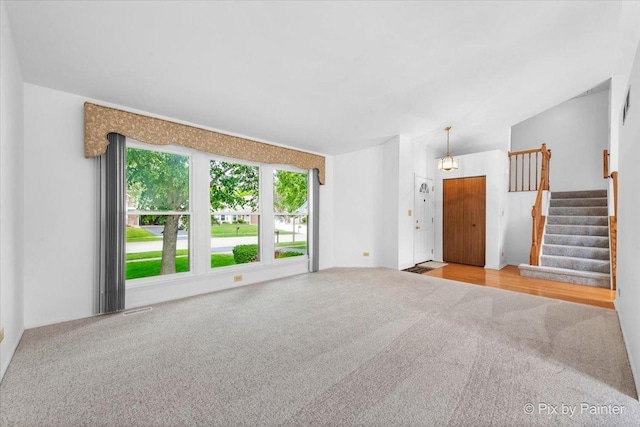 2121 Baldwin Ln, Hanover Park, IL 60133 - unfurnished living room featuring carpet floors and stairway