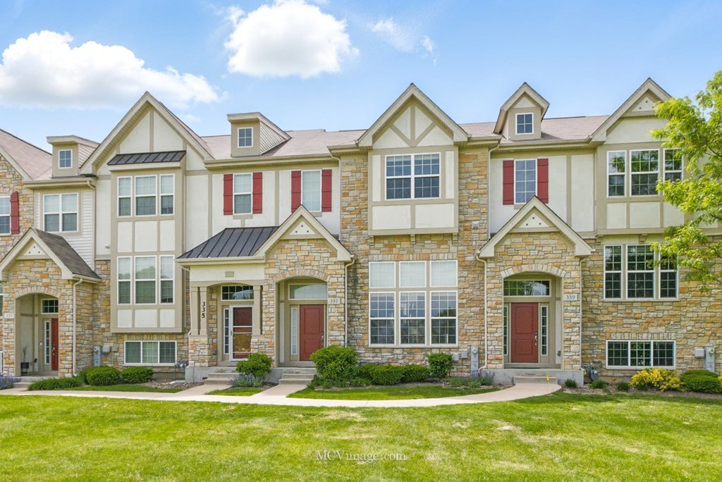 337 Bennett Dr, Carol Stream, IL 60188 - view of front facade featuring stucco siding, stone siding, a standing seam roof, and a front lawn