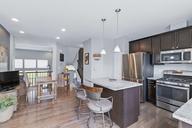 337 Bennett Dr, Carol Stream, IL 60188 - kitchen featuring stainless steel appliances, dark wood-style flooring, dark brown cabinets, a kitchen island, and light stone countertops