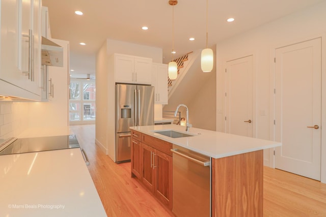 6123 S Ellis Ave, Chicago, IL 60637 - kitchen featuring appliances with stainless steel finishes, a sink, light wood-type flooring, light countertops, and white cabinetry