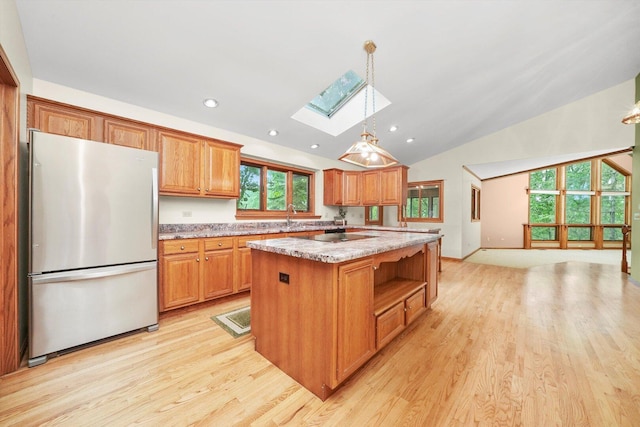 9316 Pine Needle Pass, Bull Valley, IL 60097 - kitchen with freestanding refrigerator, a skylight, light wood-style flooring, vaulted ceiling, and decorative light fixtures