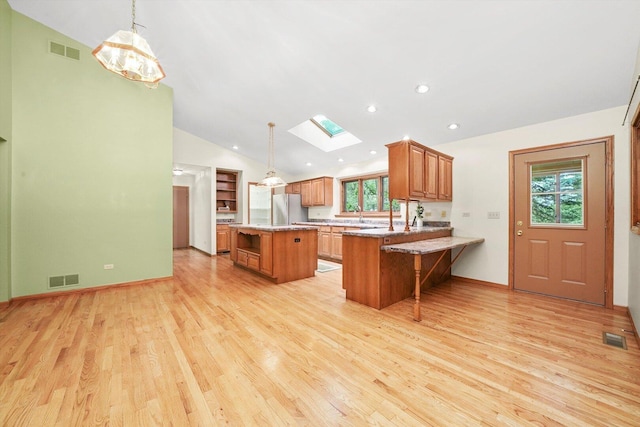 9316 Pine Needle Pass, Bull Valley, IL 60097 - kitchen featuring open shelves, brown cabinetry, healthy amount of natural light, a skylight, and lofted ceiling