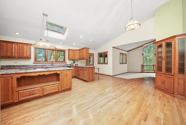 9316 Pine Needle Pass, Bull Valley, IL 60097 - kitchen with a skylight, brown cabinets, light wood-type flooring, recessed lighting, and hanging light fixtures