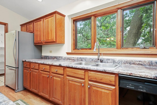9316 Pine Needle Pass, Bull Valley, IL 60097 - kitchen featuring black dishwasher, freestanding refrigerator, brown cabinets, light wood finished floors, and vaulted ceiling