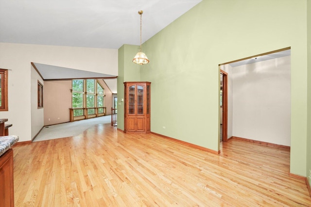 9316 Pine Needle Pass, Bull Valley, IL 60097 - unfurnished living room featuring high vaulted ceiling, light wood-style flooring, and a chandelier