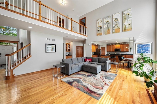 1839 Kings Gate Ln, Crystal Lake, IL 60014 - living area featuring a high ceiling, light wood finished floors, baseboards, and stairs