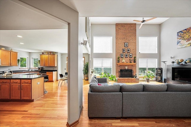 1839 Kings Gate Ln, Crystal Lake, IL 60014 - living room featuring a brick fireplace, light wood-style floors, a towering ceiling, a ceiling fan, and recessed lighting