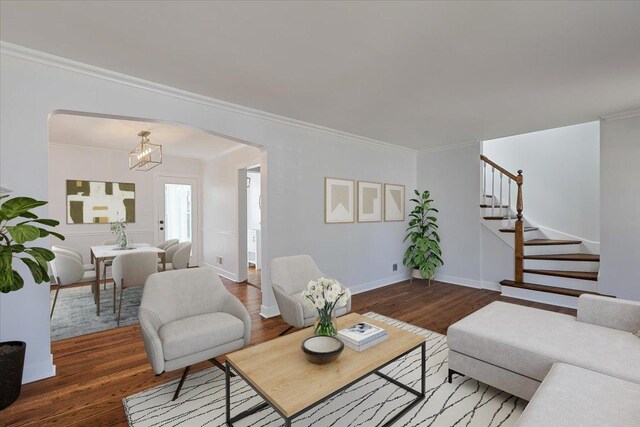 7241 N Kilpatrick Ave, Lincolnwood, IL 60712 - living room featuring arched walkways, stairs, wood finished floors, ornamental molding, and a chandelier