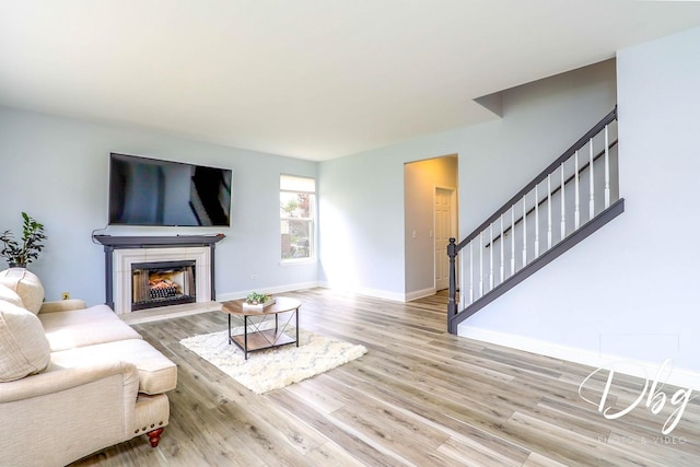 1943 Lily Ln, Round Lake, IL 60073 - living room with stairway, a tiled fireplace, and wood finished floors