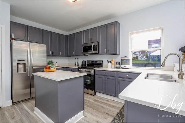 1943 Lily Ln, Round Lake, IL 60073 - kitchen featuring stainless steel appliances, light wood-style floors, light countertops, and a kitchen island
