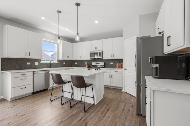 219 Conway St, Elburn, IL 60119 - kitchen featuring stainless steel appliances, light wood-type flooring, a breakfast bar, tasteful backsplash, and recessed lighting