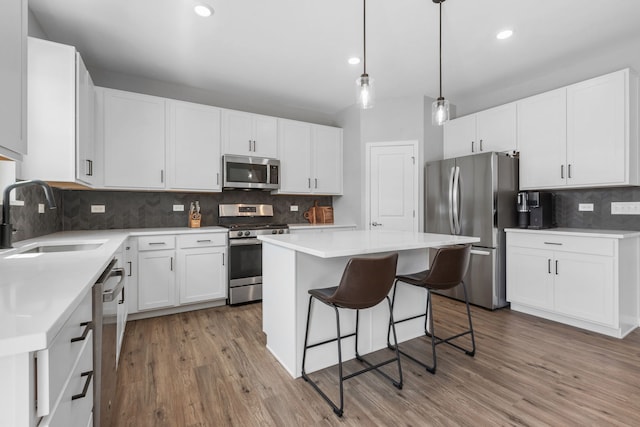 219 Conway St, Elburn, IL 60119 - kitchen with appliances with stainless steel finishes, tasteful backsplash, a center island, light wood-style floors, and recessed lighting