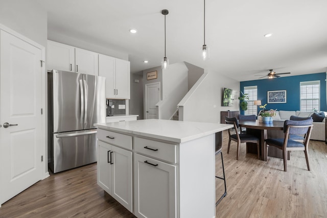 219 Conway St, Elburn, IL 60119 - kitchen featuring freestanding refrigerator, light wood finished floors, ceiling fan, open floor plan, and white cabinetry