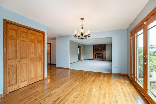 1650 Chauser Ln, Woodridge, IL 60517 - unfurnished living room with a chandelier, baseboards, light wood-style flooring, and a brick fireplace