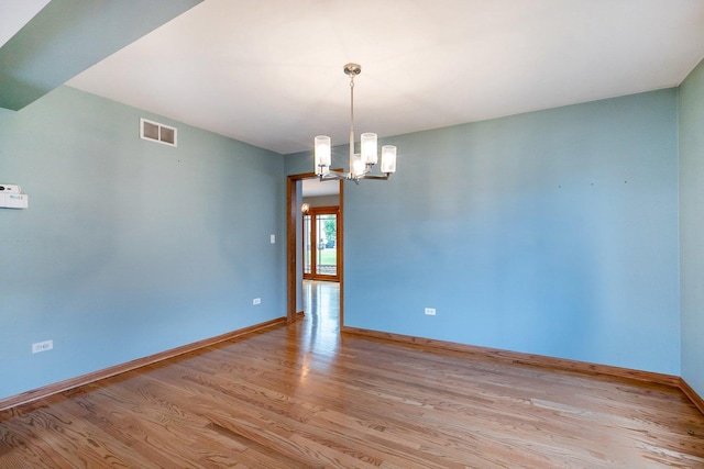 1650 Chauser Ln, Woodridge, IL 60517 - spare room featuring light wood-type flooring, baseboards, and a chandelier