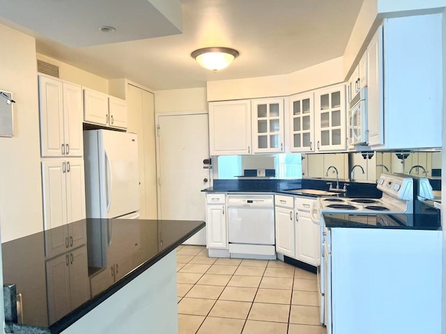 6033 N Sheridan Rd Unit 27C, Chicago, IL 60660 - kitchen featuring white appliances, dark countertops, white cabinetry, glass insert cabinets, and light tile patterned floors