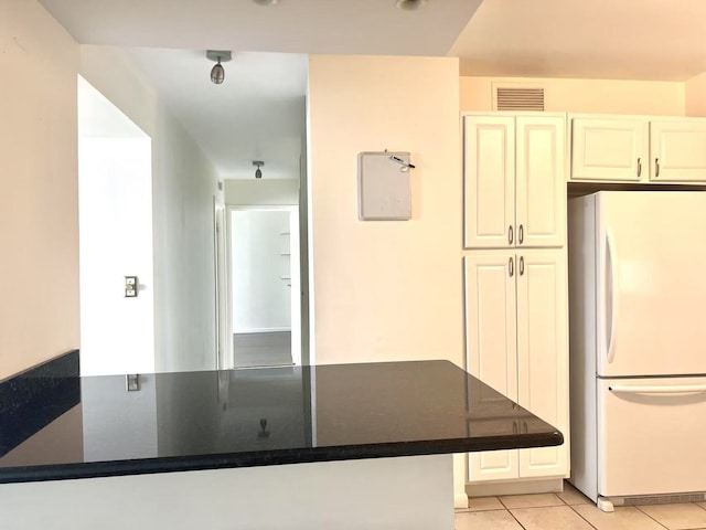 6033 N Sheridan Rd Unit 27C, Chicago, IL 60660 - kitchen with freestanding refrigerator, light tile patterned flooring, dark countertops, cream cabinets, and a peninsula