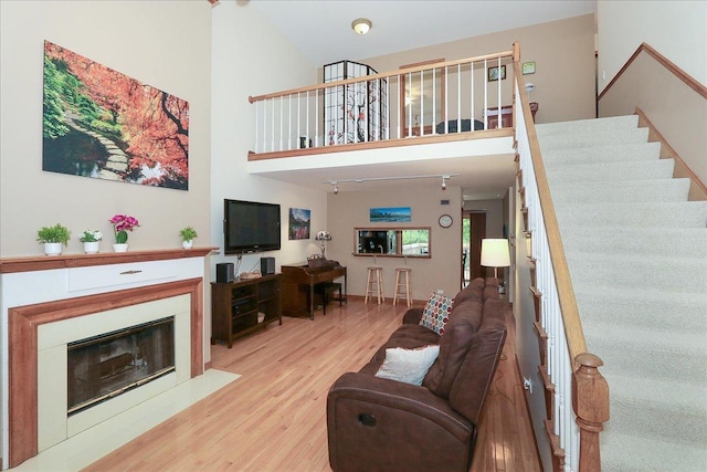 602 Cherbourg Dr, Buffalo Grove, IL 60089 - living area featuring wood finished floors, stairway, a high ceiling, and a fireplace with flush hearth