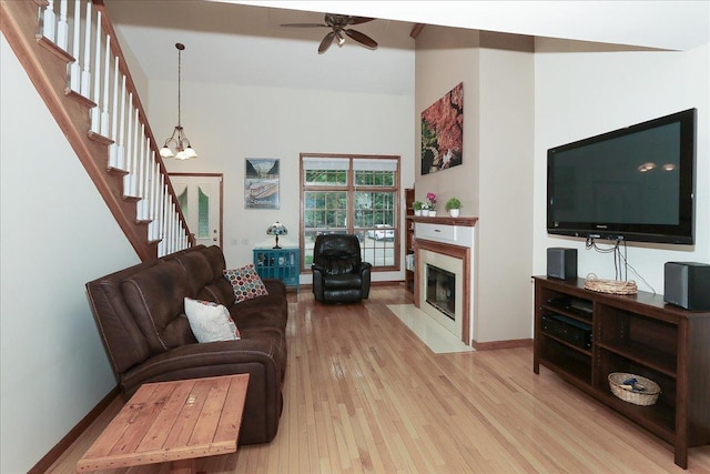 602 Cherbourg Dr, Buffalo Grove, IL 60089 - living area featuring light wood-type flooring, ceiling fan, a fireplace with flush hearth, stairway, and a high ceiling