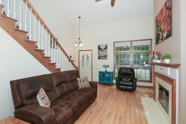 602 Cherbourg Dr, Buffalo Grove, IL 60089 - living area with wood-type flooring, a chandelier, stairs, a high end fireplace, and a towering ceiling