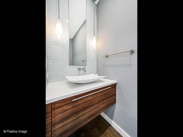 1229 N Cleaver St Unit 1, Chicago, IL 60642 - bathroom featuring decorative backsplash, vanity, wood finished floors, and lofted ceiling