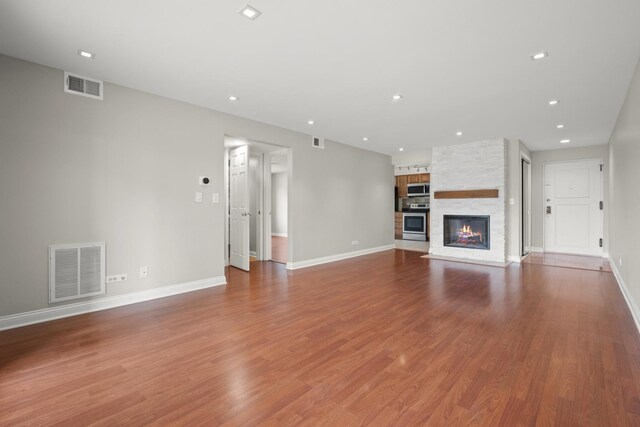 5332 N Delphia Ave Unit 108, Chicago, IL 60656 - unfurnished living room featuring baseboards, a large fireplace, recessed lighting, and wood finished floors