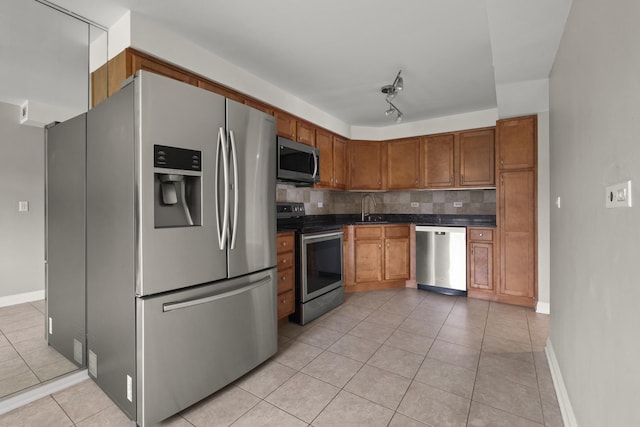 5332 N Delphia Ave Unit 108, Chicago, IL 60656 - kitchen with stainless steel appliances, dark countertops, light tile patterned floors, backsplash, and brown cabinetry