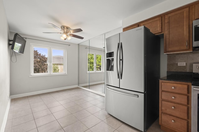 5332 N Delphia Ave Unit 108, Chicago, IL 60656 - kitchen with stainless steel appliances, a ceiling fan, decorative backsplash, baseboards, and light tile patterned floors