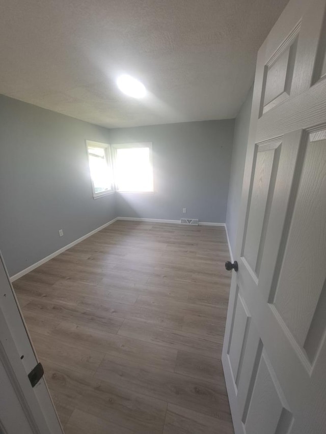 3025 Central Ave, Rockford, IL 61102 - spare room featuring wood finished floors, baseboards, and a textured ceiling