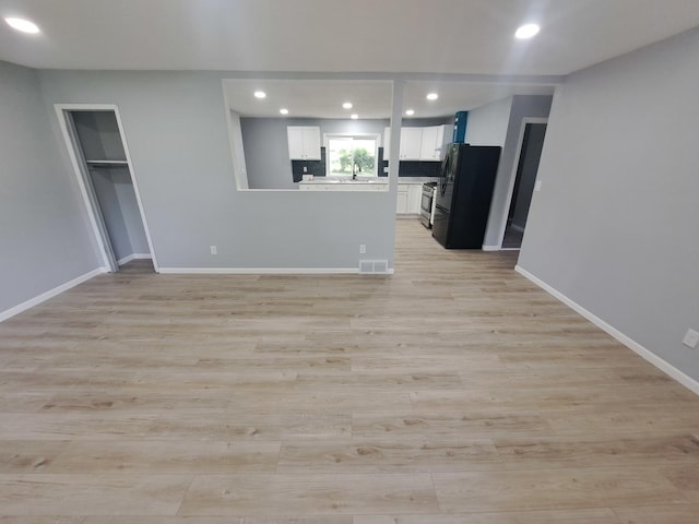 3025 Central Ave, Rockford, IL 61102 - unfurnished living room with a sink, light wood finished floors, recessed lighting, and baseboards