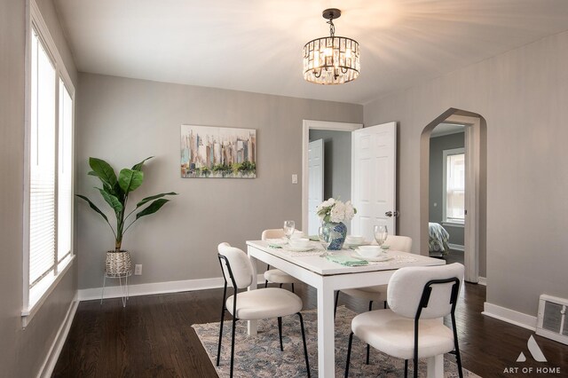 12480 S Wabash Ave, Chicago, IL 60628 - dining room featuring arched walkways, baseboards, a chandelier, and dark wood finished floors