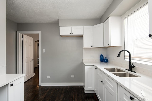 12480 S Wabash Ave, Chicago, IL 60628 - kitchen featuring a sink, dark wood-type flooring, a textured ceiling, light countertops, and white cabinetry