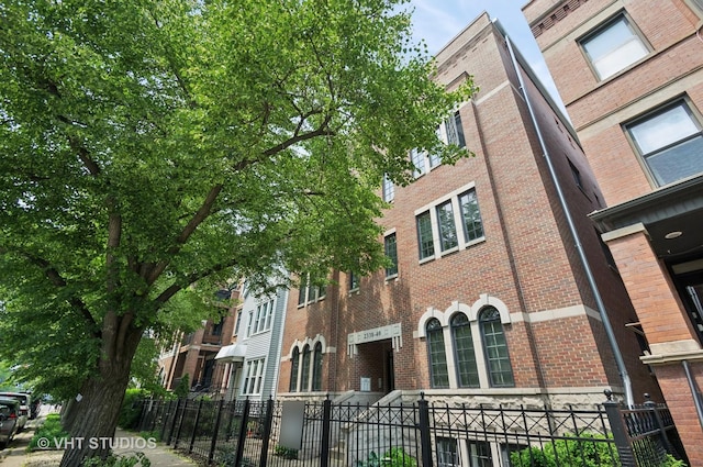 2338 W Roscoe St Unit 2E, Chicago, IL 60618 - view of building exterior featuring a fenced front yard