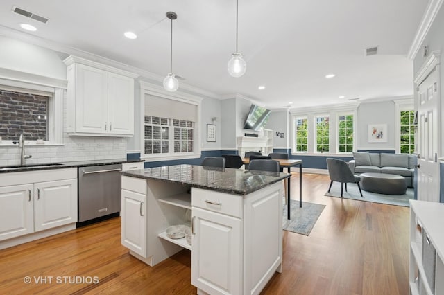 2338 W Roscoe St Unit 2E, Chicago, IL 60618 - kitchen with stainless steel dishwasher, open floor plan, ornamental molding, light wood-type flooring, and a kitchen island