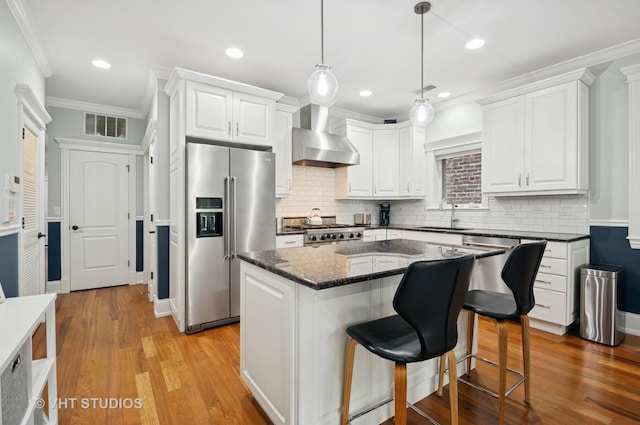 2338 W Roscoe St Unit 2E, Chicago, IL 60618 - kitchen featuring high end fridge, wall chimney exhaust hood, range, crown molding, and white cabinets