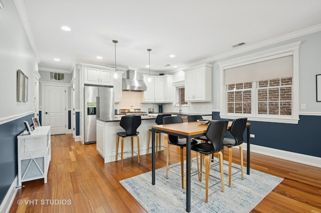 2338 W Roscoe St Unit 2E, Chicago, IL 60618 - dining space with light wood-style floors, ornamental molding, and recessed lighting