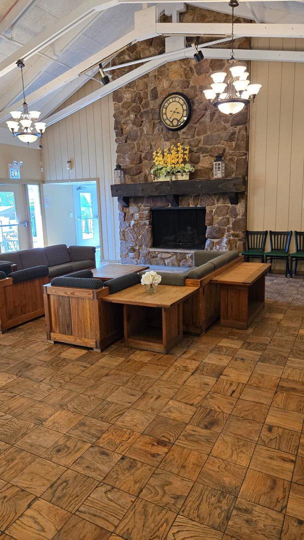 222 Oakwood Ln, Bloomingdale, IL 60108 - living area with a stone fireplace, a chandelier, beamed ceiling, and high vaulted ceiling