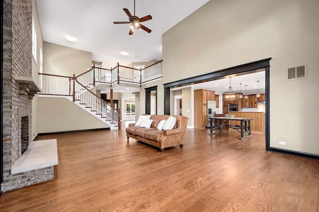 808 Maple Ave, Downers Grove, IL 60515 - living area featuring a high ceiling, a ceiling fan, wood finished floors, stairway, and a large fireplace