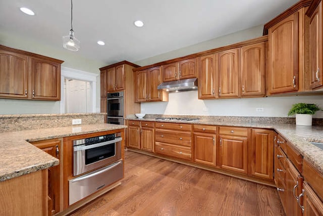 808 Maple Ave, Downers Grove, IL 60515 - kitchen featuring under cabinet range hood, a warming drawer, appliances with stainless steel finishes, wood finished floors, and pendant lighting