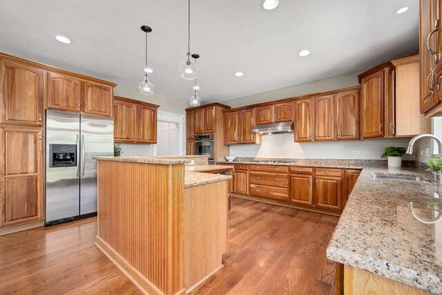 808 Maple Ave, Downers Grove, IL 60515 - kitchen featuring appliances with stainless steel finishes, a sink, under cabinet range hood, a center island, and light stone countertops