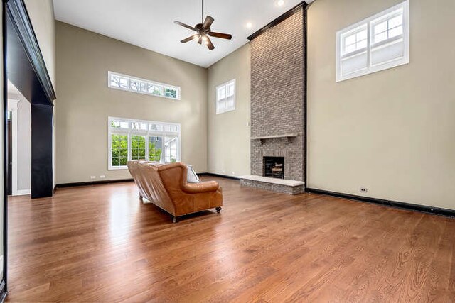 808 Maple Ave, Downers Grove, IL 60515 - living room with a high ceiling, ceiling fan, wood finished floors, a large fireplace, and baseboards