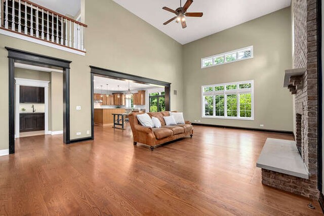 808 Maple Ave, Downers Grove, IL 60515 - living area featuring high vaulted ceiling, a ceiling fan, a brick fireplace, wood finished floors, and baseboards