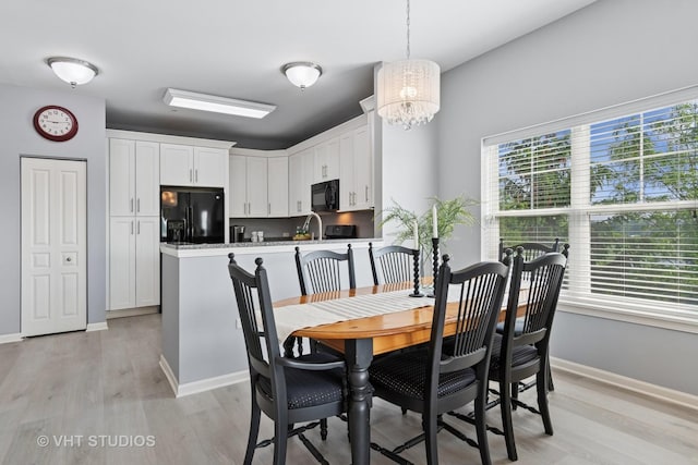 3975 Idlewild Ln Unit 200, Naperville, IL 60564 - dining room featuring light wood-style flooring, a chandelier, and baseboards