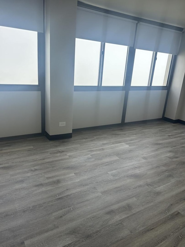 empty room featuring wood finished floors and baseboards
