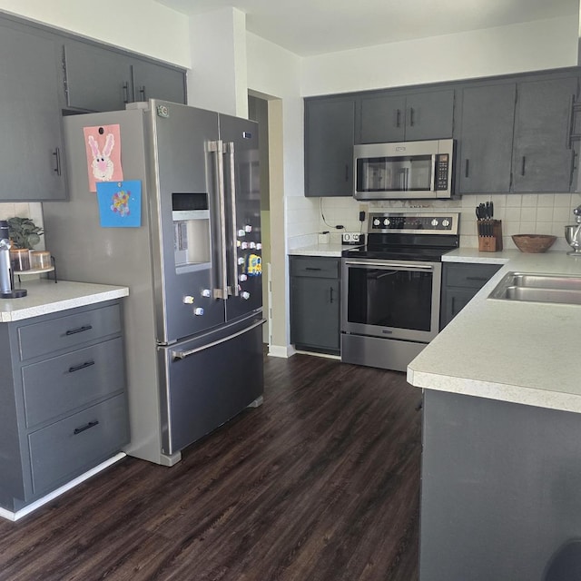 421 W 1st St, Stillman Valley, IL 61084 - kitchen featuring stainless steel appliances, a sink, dark wood-style flooring, backsplash, and gray cabinets