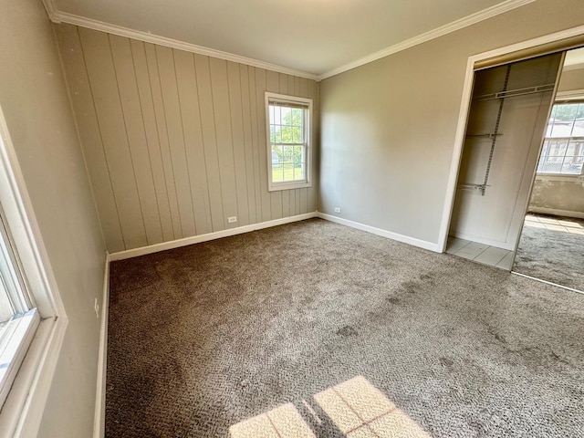 814 Spruce Ct, Streamwood, IL 60107 - unfurnished bedroom featuring multiple windows, carpet flooring, ornamental molding, a closet, and wood walls