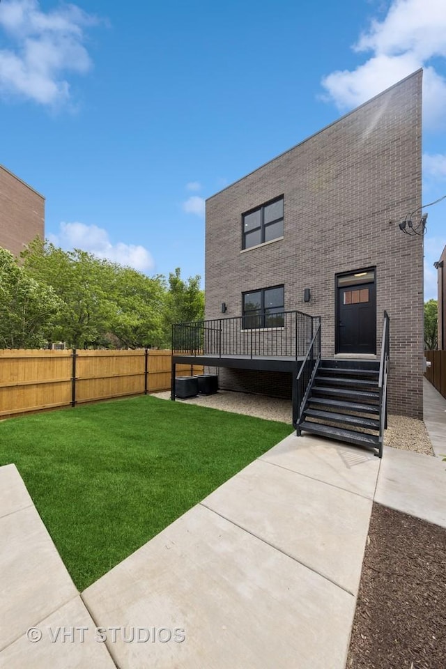 3300 S Giles Ave, Chicago, IL 60616 - rear view of house featuring a fenced backyard, a wooden deck, a patio, and brick siding