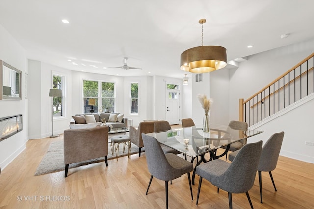 3300 S Giles Ave, Chicago, IL 60616 - dining room with light wood-style floors, recessed lighting, stairway, a ceiling fan, and a glass covered fireplace